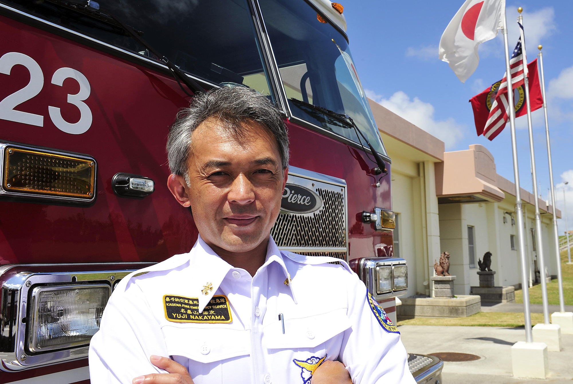 Yuji Nakayama, the 18th Civil Engineer Squadron district chief, poses for a photo in front of a fire truck on Kadena Air Base, Japan, April 2, 2015. Nakamura, who has been working at the fire department for more than 22 years, recently won the 2014 Air Force Fire Officer of the Year award, civilian category, for his hard work and dedication. (U.S. Air Force photo/Naoto Anazawa)