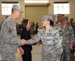 Oregon National Guard Airman 1st Class Lindsey Gallardo, assigned to the 116th Air Control Squadron (ACS), right, is greeted by Maj. Gen. Daniel R. Hokanson, the adjutant general for Oregon, left, as Airmen from the unit conclude their formal mobilization ceremony at Camp Withycombe, Ore., April 11, 2015. 