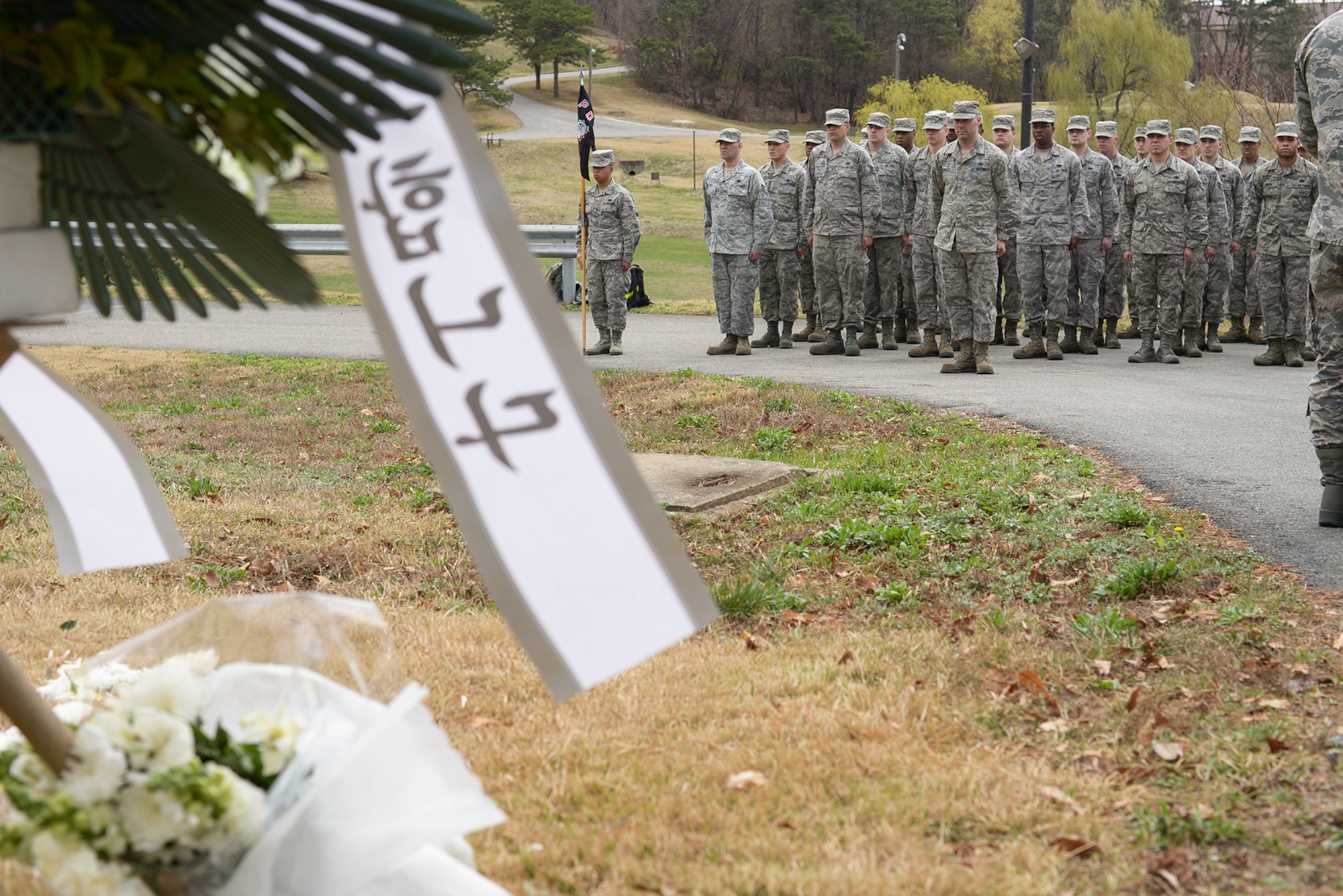 Members of the 51st Logistics Readiness Squadron stand in formation during a memorial ceremony April 4, 2015, at Osan Air Base, Republic of Korea. The ceremony honored the memory of 16 people who died in a jet-fuel fire on April 5, 1986. (U.S. Air Force photo by Staff Sgt. Jake Barreiro/Released)