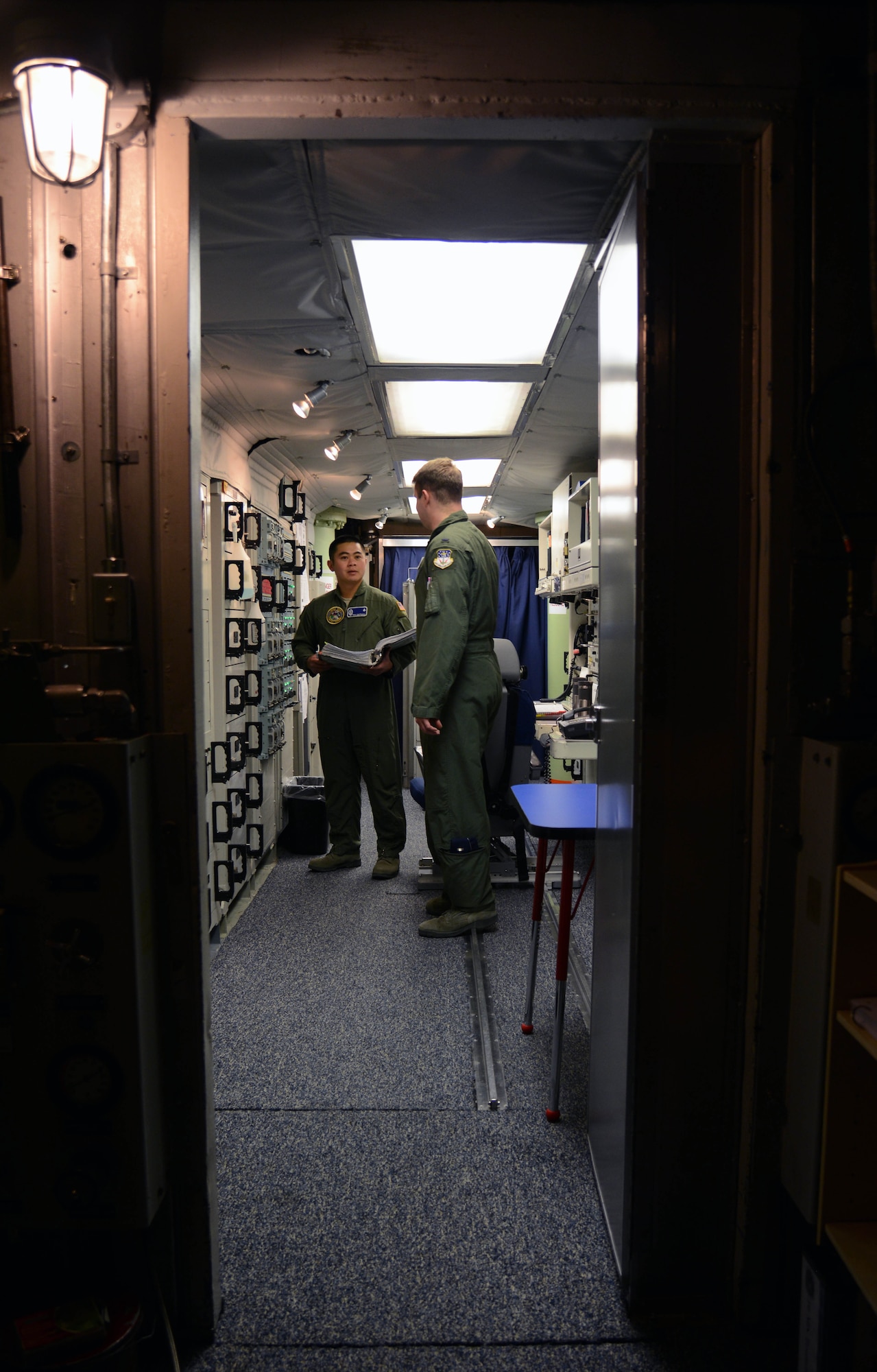 1st Lt. Tony Onitsuka, left, 10th Missile Squadron flight commander, and 1st Lt. Will Coley, 10th MS deputy flight commander, check the status of their communications equipment March 16, 2015, at a launch control center near Malmstrom Air Force Base, Mont. Regular maintenance and checks are required to ensure there is a stable communications network to the LCC. (U.S. Air Force photo/ Airman 1st Class Dillon Johnston)