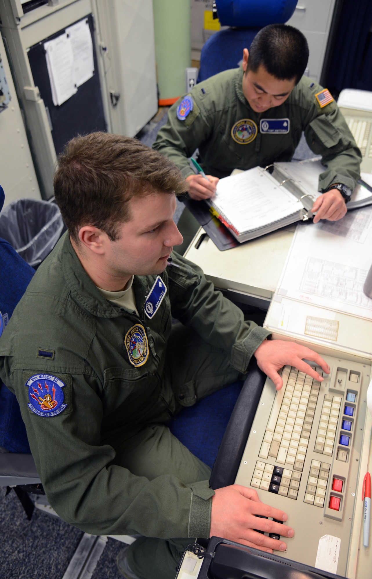 1st Lt. Tony Onitsuka, top, 10th Missile Squadron flight commander, and 1st Lt. Will Coley, 10th MS deputy flight commander, check the status of a launch facility March 16, 2015, at a launch control center near Malmstrom Air Force Base, Mont. Missileers regularly check in with LFs to ensure they are functioning correctly. (U.S. Air Force photo/ Airman 1st Class Dillon Johnston)