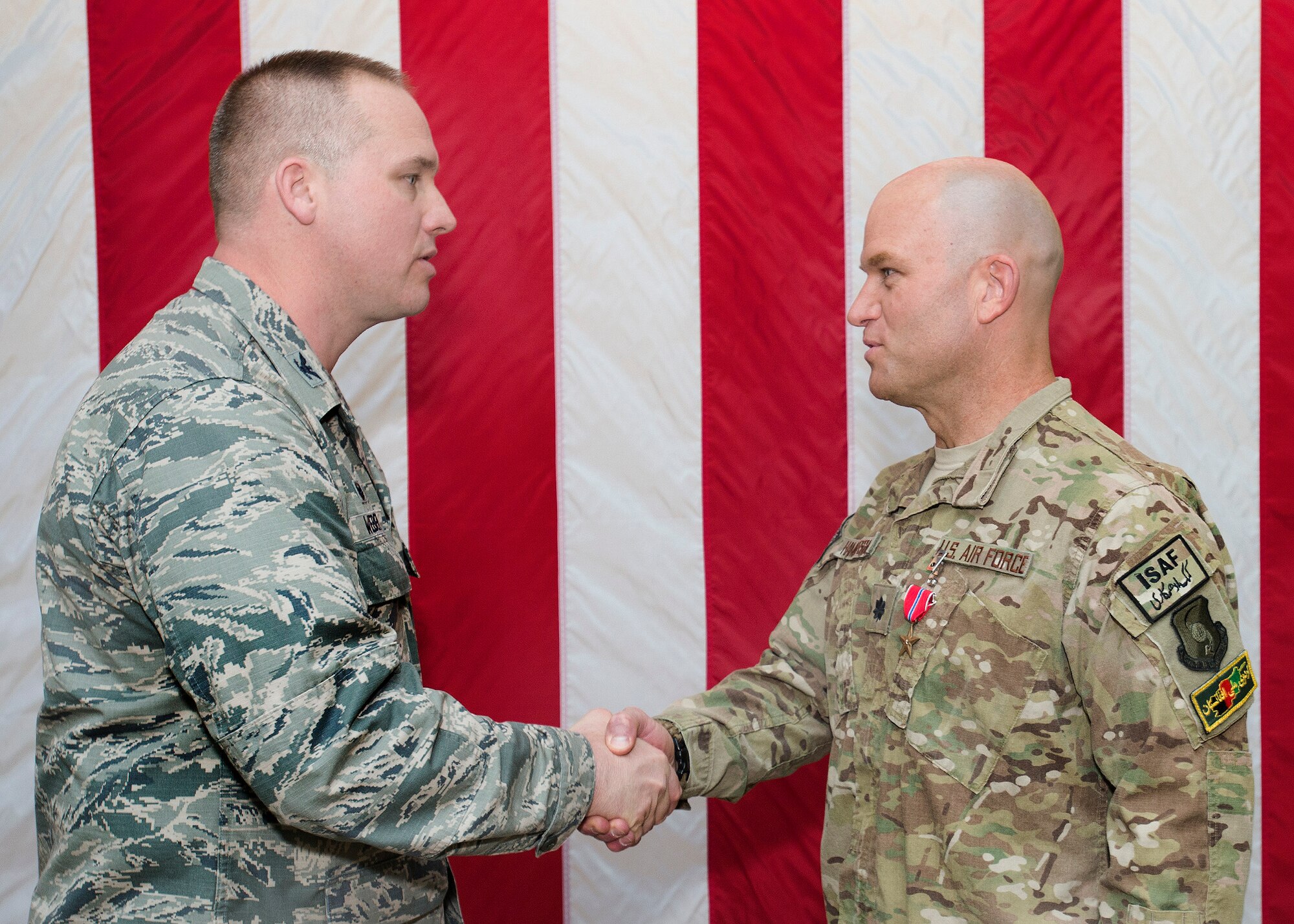 Col. Mark Weber, 60th Maintenance Group commander, presents the Bronze Star to Lt. Col. David Hammerschmidt, 60th MXG deputy commander, April 9 at Travis Air Force Base, Calif., for his achievements while deployed to Afghanistan. Approximately 60 members of the Travis community were on hand at the maintenance group atrium for the presentation. (U.S. Air Force photo by T.C. Perkins)