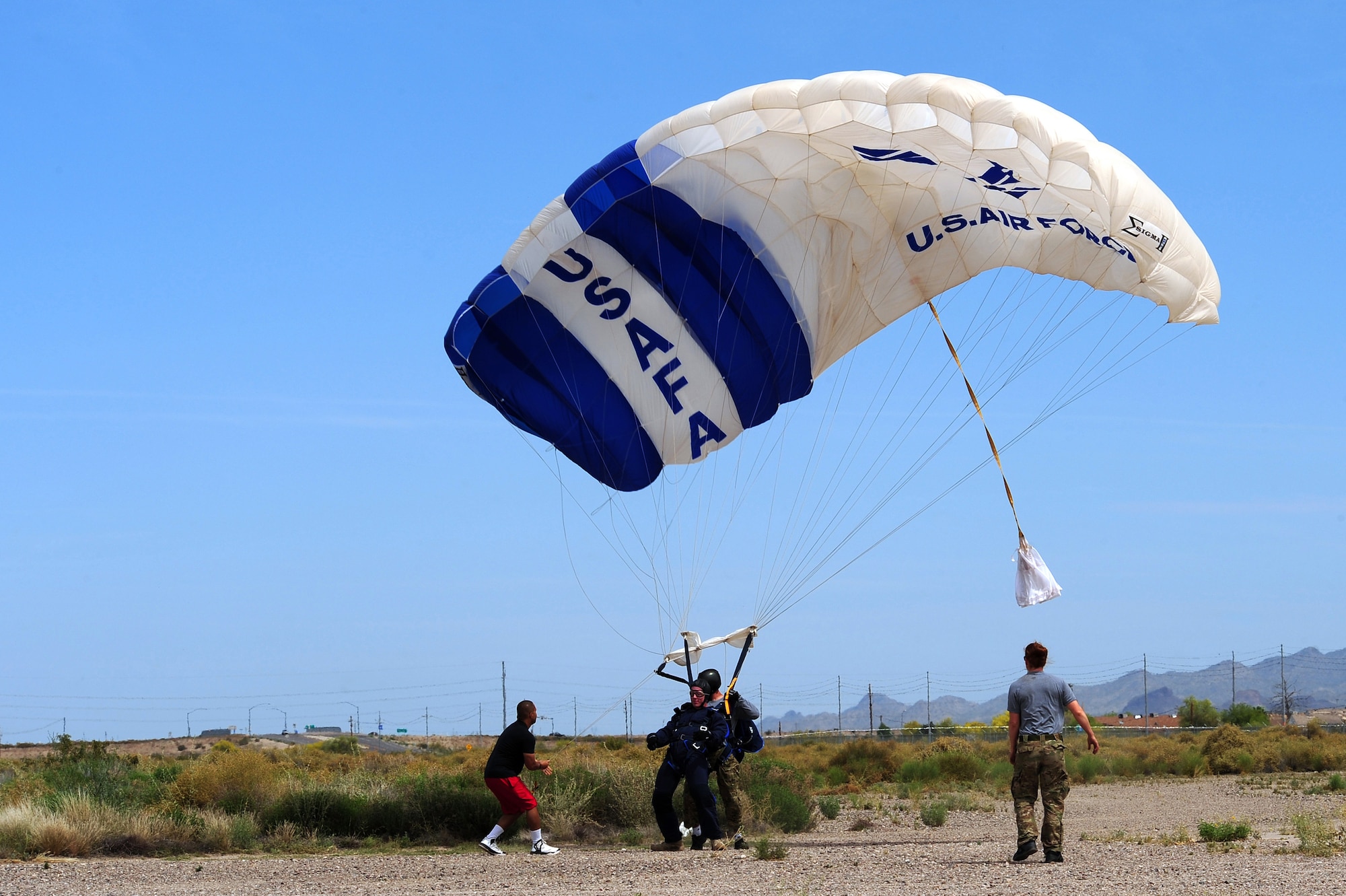 U.S. Air Force Senior Airman Matthew Shoup, 355th Civil Engineering Squadron explosive ordnance disposal apprentice, and Master Sgt. Jason Nyman, 98th Flying Training Squadron parachute jump instructor, land after a tandem skydive at Desert Skydiving Center in Buckeye, Ariz., April 2, 2015. During their freefall, Shoup and Airmen from Davis-Monthan AFB reached speeds of more than 100 mph. (U.S. Air Force photo by Airman 1st Class Chris Drzazgowski/Released)