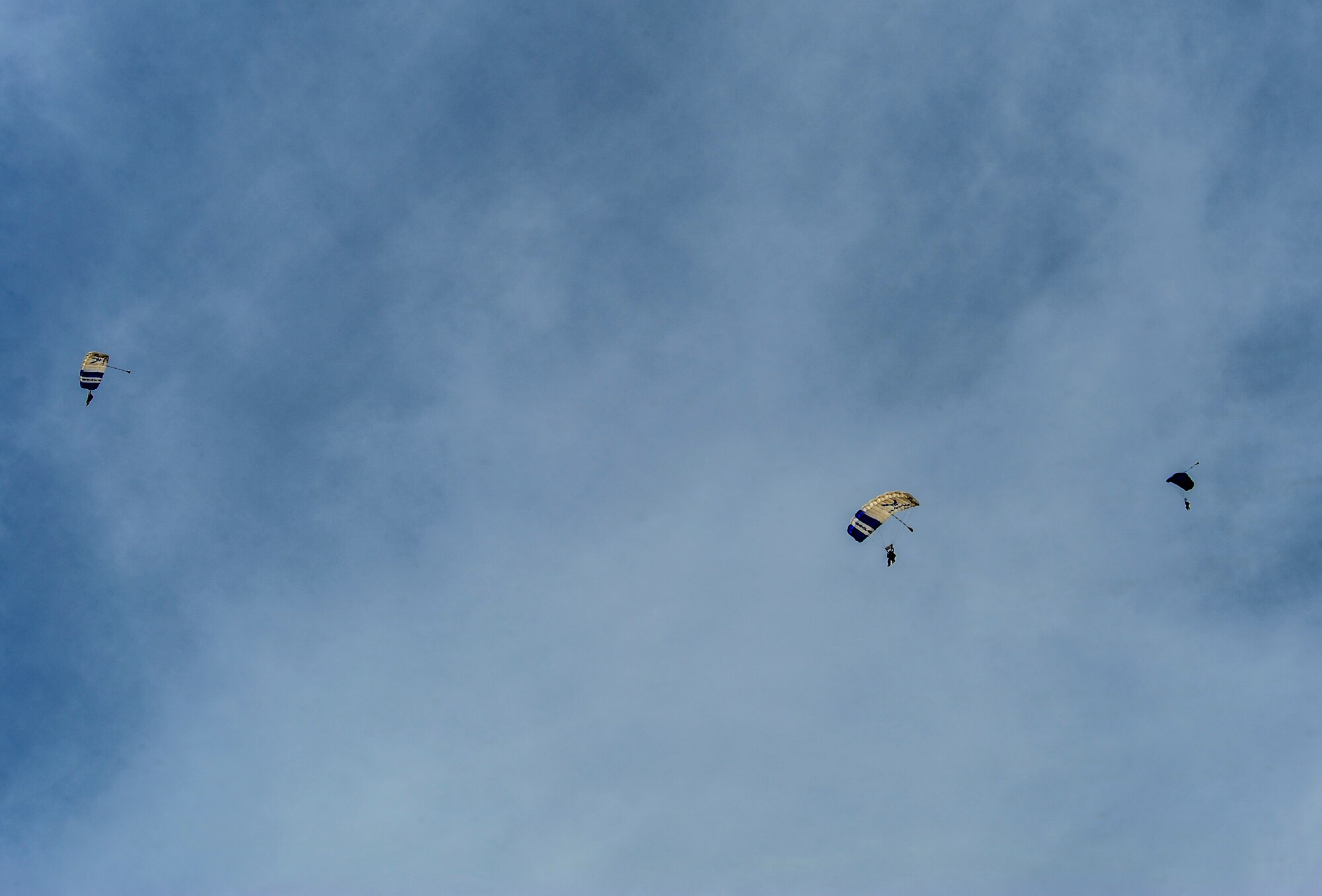 Airmen from Davis-Monthan Air Force Base and parachute instructors from the 98th Flying Training Squadron parachute to the airfield at Desert Skydiving Center in Buckeye, Ariz., April 2, 2015. Instructors from the 98th FTS provided Airmen from Davis-Monthan Air Force Base tandem skydiving as a way to thank D-M for its frequent accommodations in support of the squadron’s mission. (U.S. Air Force photo by Airman 1st Class Chris Drzazgowski/Released)
