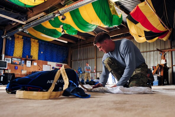 U.S. Air Force Master Sgt. Jason Nyman, 98th Flying Training Squadron parachute jump instructor, packs his parachute at Desert Skydiving Center in Buckeye, Ariz., April 2, 2015. Instructors from the 98th FTS provided Airmen from Davis-Monthan Air Force Base tandem skydiving as a way to thank D-M for its frequent accommodations in support of the squadron's mission. (U.S. Air Force photo by Airman 1st Class Chris Drzazgowski/Released)