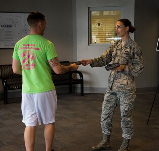 Senior Airman Dana Horn, 628th Communications Squadron emergency actions controller, hands out Holocaust remembrance cards to members of Joint Base Charleston April 16, 2015, at the Fitness Center on Joint Base Charleston, S.C. There were 1,000 total cards given out that day. Each card represented 6,000 people that lost their lives in the Holocaust. (U.S. Air Force photo/Airman 1st Class Clayton Cupit)