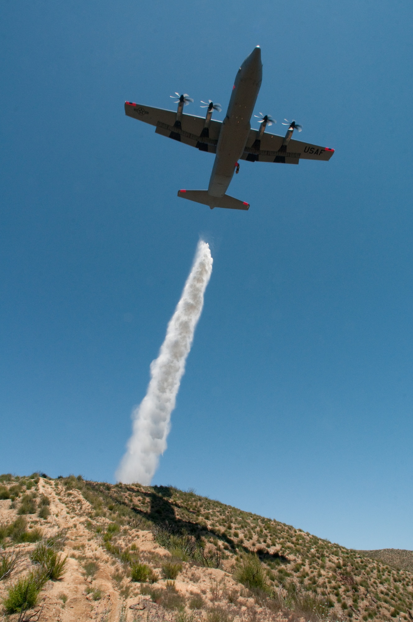 146th Airlift Wing MAFFS-equipped C-130J, California Air National Guard, drops water over the Angeles National Forest May 14, 2013. The 146th Airlift Wing held their annual Modular Airborne Firefighting Systems (MAFFS) recertification and training in partnership with U.S. Forest Service and CAL FIRE to prepare for the upcoming wildfire season. (U.S. Air National Guard photo by Staff Sgt. Nick Carzis)