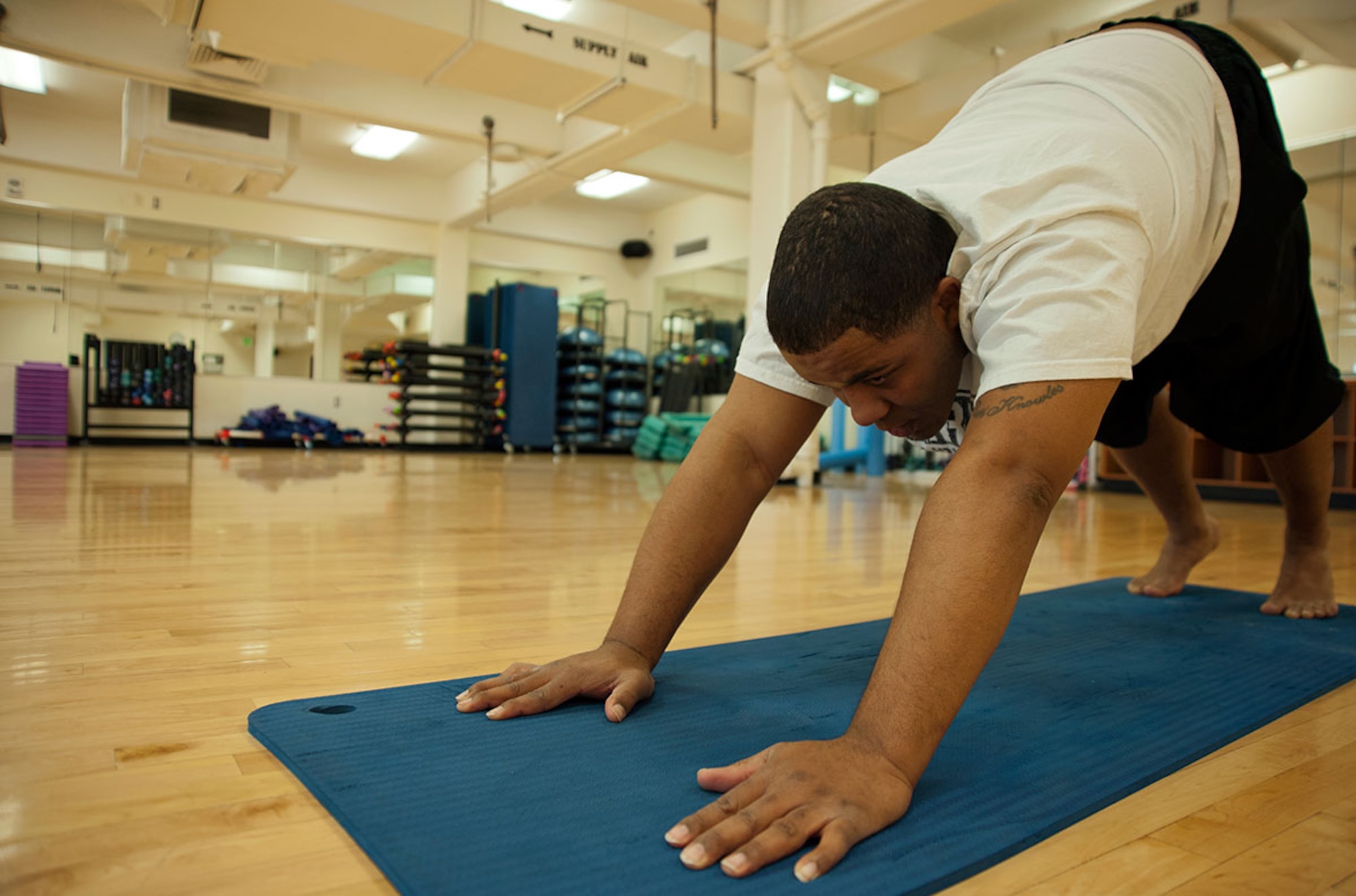 Tech. Sgt. Leonard Simmons, 703rd Aircraft Maintenance Squadron expediter, stretches before exercising at the Elmendorf Fitness Center on Joint Base Elmendorf-Richardson, Alaska, April 13, 2015. Simmons is preparing for hip surgery by losing weight and eating healthy with the help of the Better Body, Better Life class taught at the Health and Wellness Center. (U.S. Air Force photo/Airman 1st Class Tammie Ramsouer)