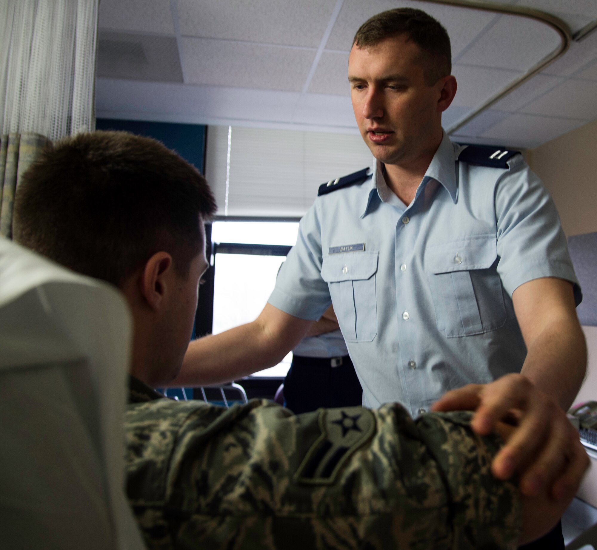 Capt. Thomas Bayuk, 48th Medical Operations Squadron physician, evaluates the range of motion and current pain level of Airman 1st Class Tyler Denis, 779th Medical Operations Squadron member, at the Malcom Grow Medical Clinics and Surgery Center, Joint Base Andrews, Md., April 15, 2015. Evaluating pain level is the first step for physicians in a training program to become certified and licensed as physician acupuncturists. (U.S. Air Force photo/Airman 1st Class Philip Bryant)