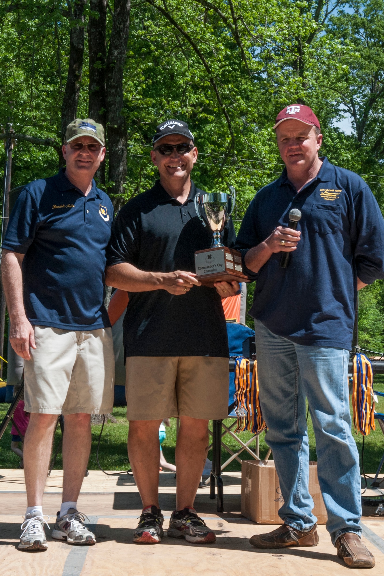 Mark Geer (center), the deputy commander for the 307th Mission Support Group is presented the Commander’s Cup Challenge trophy for the most group wins during the 307th Bomb Wing Family Day Games on Barksdale Air Force Base, La on April 11th. Presenting the trophy is Bruce Cox (right), the commander of the 307th Bomb Wing, and Randy Noble (left), the command chief for the 307th Bomb Wing. The family day is an annual event for reservists to bring their families, play games, and visit with each other. (U.S. Air Force photo by Master Sgt. Dachelle Melville/Released)