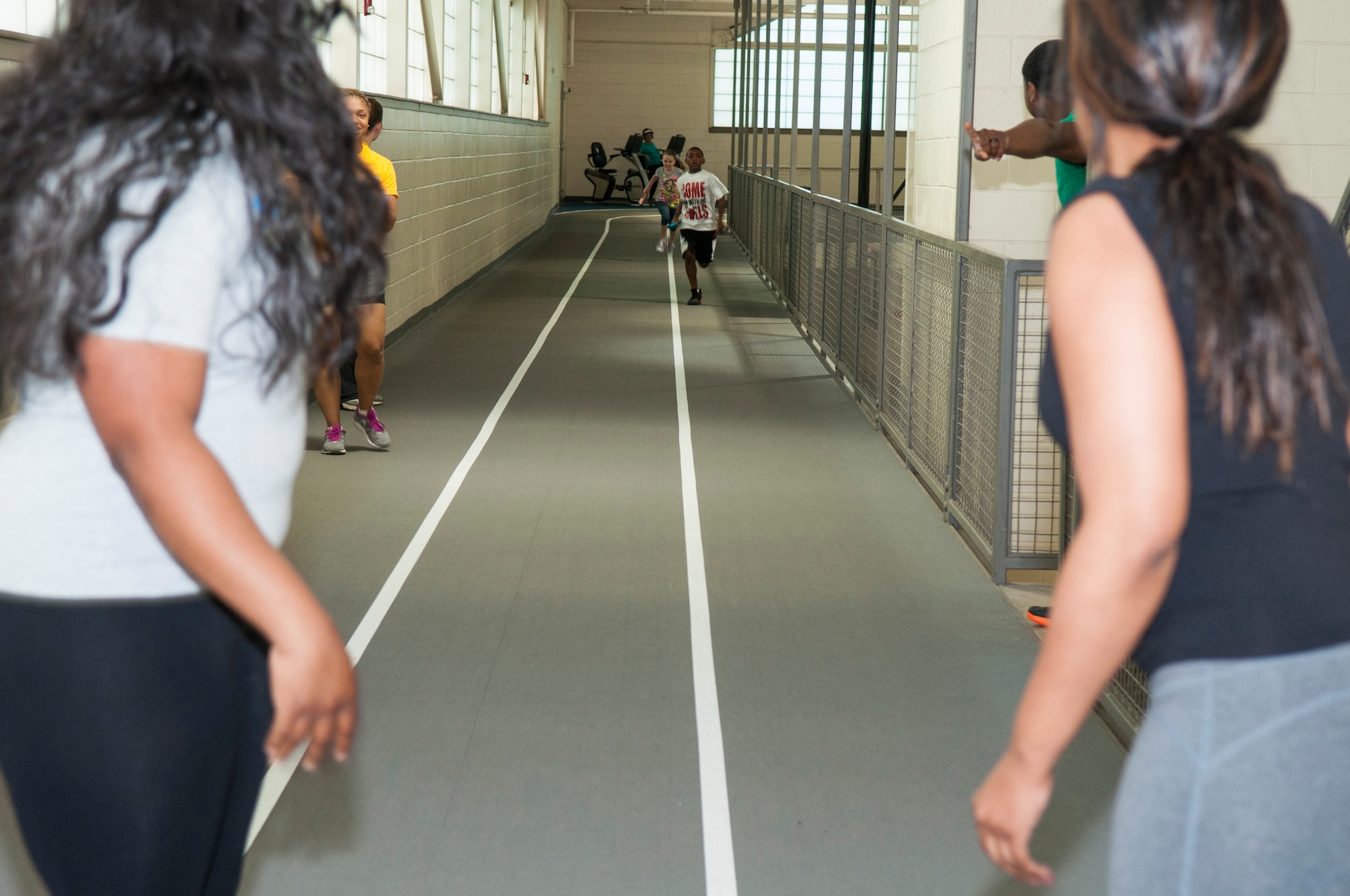 Two kids run to finish the first lap of a relay race at the Senior Airman Bryan Bell Fitness Center on Barksdale Air Force Base, La. The relay race was just one of many games that were a part of the 307th Bomb Wing Family Day held on April 11th. Reservists and their families were able to compete for Olympic style medals while enjoying a picnic. (U.S. Air Force photo by Master Sgt. Dachelle Melville/Released)