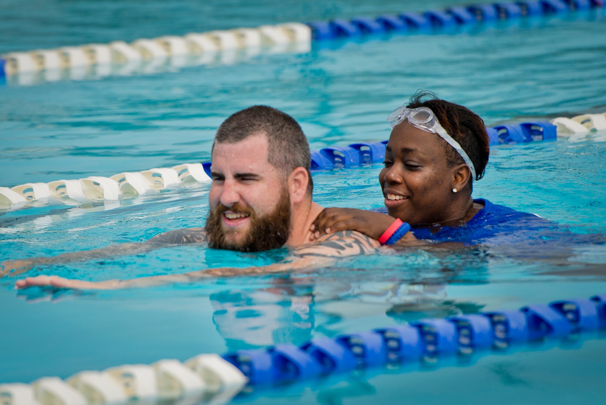 Jarrett Cox helps his old friend Lucy Jones, around the pool during the third day of an introductory adaptive sports and rehabilitation camp at Eglin Air Force Base, Fla., April 15.  Cox and Jones were deployed together to Baghdad in 2009.  During their deployment, their convoys were attacked simultaneously.  An explosion flipped Jones’ Humvee and left her submerged in water.  The former security forces Airmen hadn’t seen each other in four years and did not know the other would be attending.  The camp became a reunion for them.  Cox gladly helped his friend attempt to overcome her fear of water during their time in the pool.  The DOD’s military adaptive sports program enhances warrior recovery by engaging wounded, ill and injured service members in ongoing, daily adaptive activities, based on their interest and ability. (U.S. Air Force photo/Samuel King Jr.)