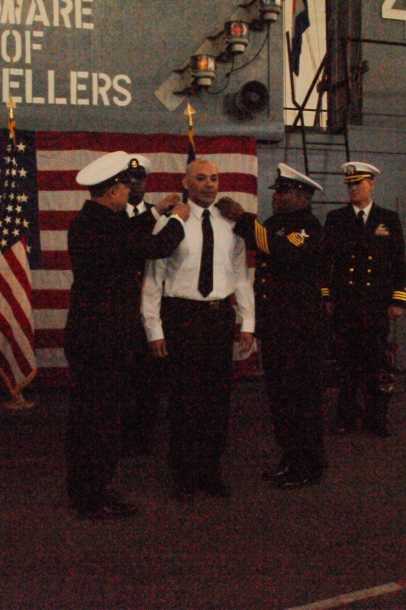 U.S. Navy Chief Petty Officer Byron Rios, 87th Civil Engineer Squadron, has
his enlisted rank removed by two chief petty officers during his
transitioning ceremony aboard a mock aircraft carrier flight deck in Hangar
One at Joint Base McGuire-Dix-Lakehurst, N.J., April 3, 2015. Rios' now
fellow warrant officers, family, friends and shipmates mustered to witness
his transition from the enlisted rank of chief petty officer to chief
warrant officer two. (U.S. Air Force photo by Pascual Flores/Released)
