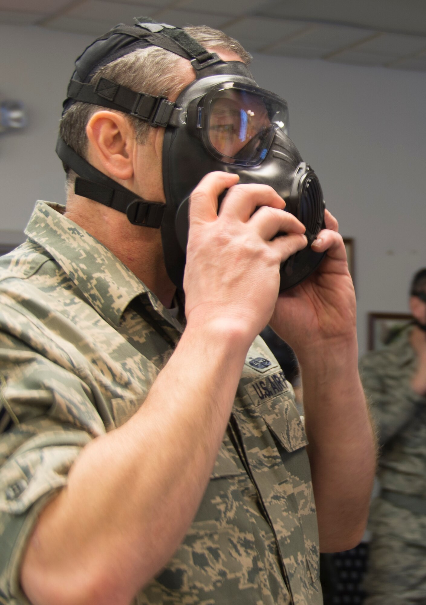 Master Sgt. Marshall Gillespie, 512th Airlift Control Flight, adjusts the fitting of his protective gas mask Feb. 7, 2015, at Dover Air Force, Del. Gillespie and other 512th Airlift Wing reservists participated in training to respond to attacks that involve chemical, biological, radiological and nuclear weapons. (U.S. Air Force photo/Staff Sgt. Mercedes Crossland)