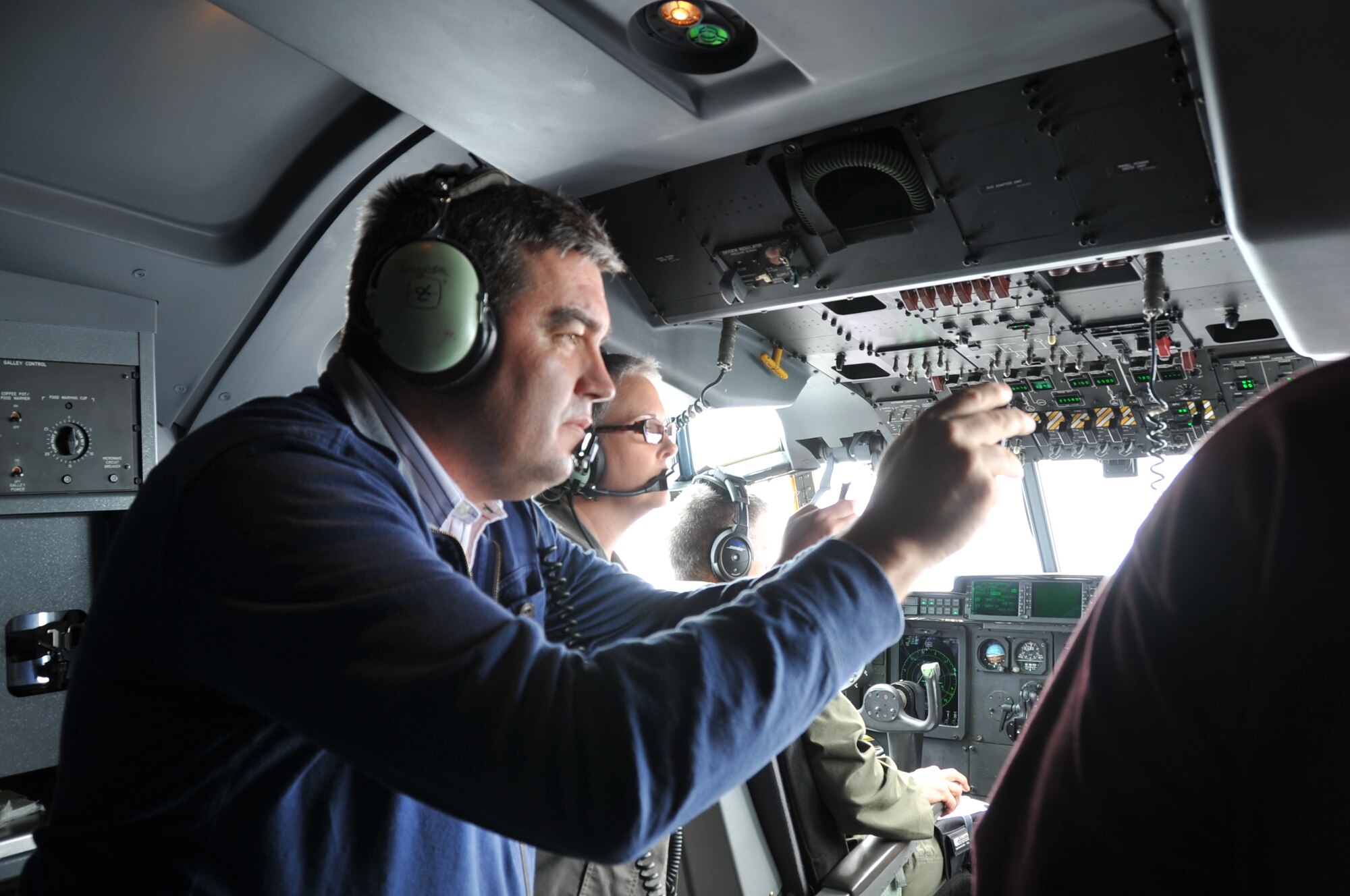 Mr. Rodney Acevedo, employer from Chevron Oak Point (front), and Ms. Debra Gilley, an employer from the Veterans Administration Gulf Coast Veteran Health Care System (back) take photographs out of the cockpit window during the C130J flight during the 403rd Wing Employer Appreciation Day at Keesler Air Force Base, Mississippi, April 11, 2015.  Employers were given a tour, demonstrations, and participated in a flight on the 403rd Wing aircraft a C130J.  (U.S. Air Force photo/Master Sgt. Jessica Kendziorek)