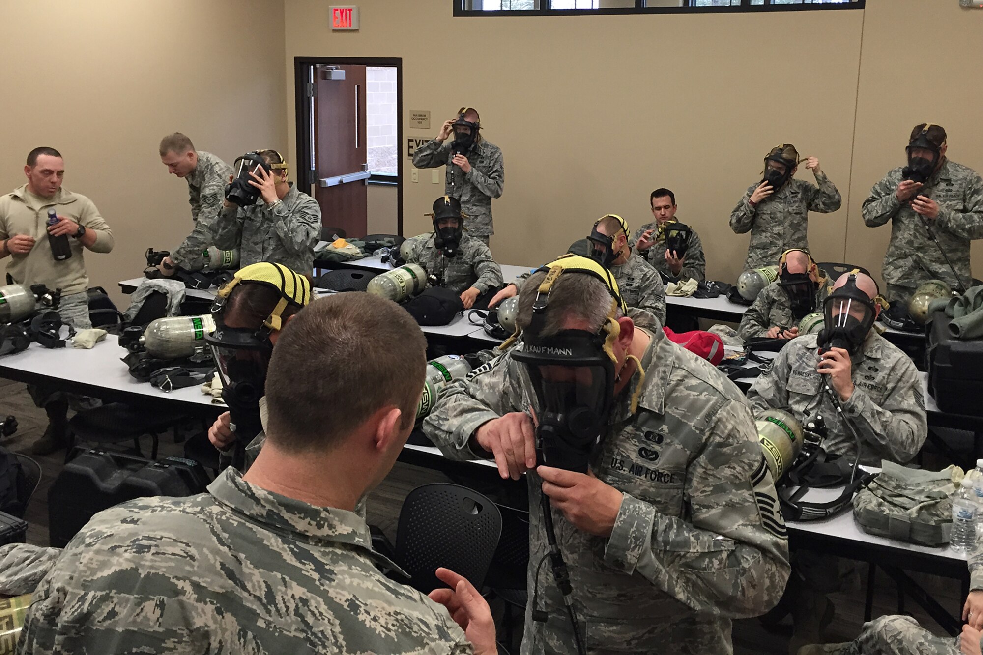 Air National Guard and Air Force Reserve emergency management specialists put on gas masks during a training session at the Alpena Combat Readiness Training Center, Mich., April 8, 2015. Emergency management Airmen from six states recently gathered in Alpena to conduct a series of training exercises and classes to maintain their skill proficiency. (U.S. Air National Guard photo)