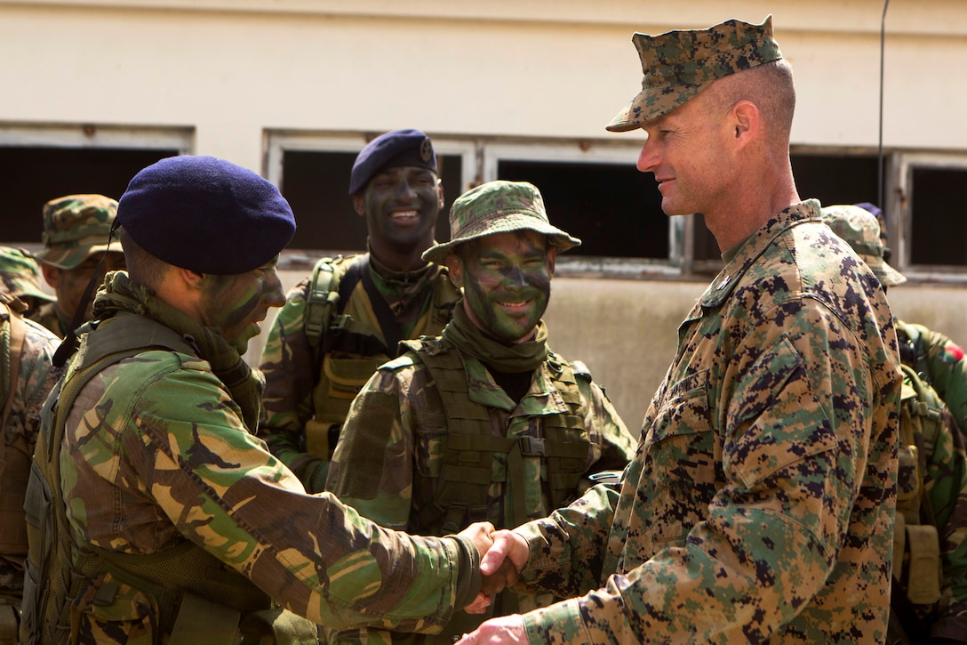 U.S. Marine Corps Col. Thomas Savage, right, commander of Special-Purpose Marine Air-Ground Task Force Crisis Response-Africa, shakes hands with a Portuguese Marine following assault training exercise near Lisbon, Portugal, April 10, 2015.