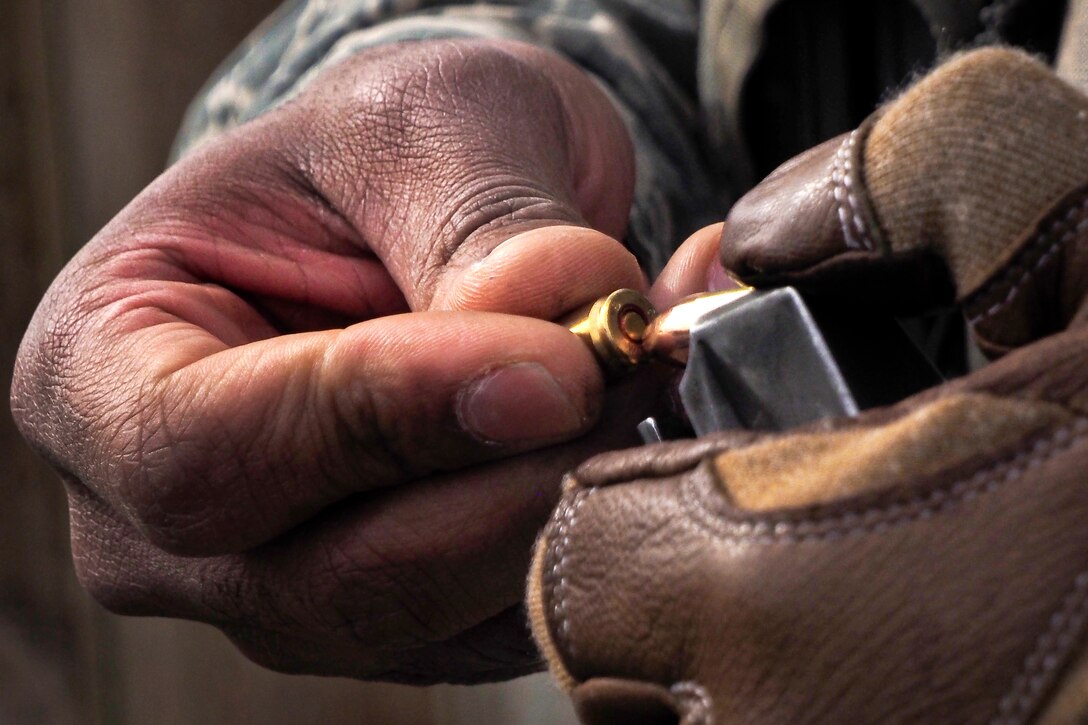 A paratrooper loads an M9 pistol magazine at the combat pistol range on Joint Base Elmendorf-Richardson, Alaska, April 14, 2015.