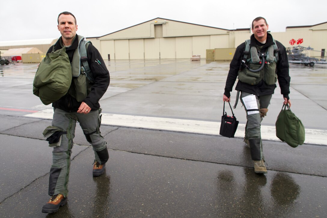 Air Force Majs. Gary "Wilco" Wallace, left, and wingman Clayton "Fokker" Johnson walk to F-22 Raptors before a sortie on Joint Base Elmendorf-Richardson, Alaska, April 8, 2015. Wallace is a pilot assigned to the 90th Fighter Squadron and Johnson is a pilot assigned to the 302nd Fighter Squadron.