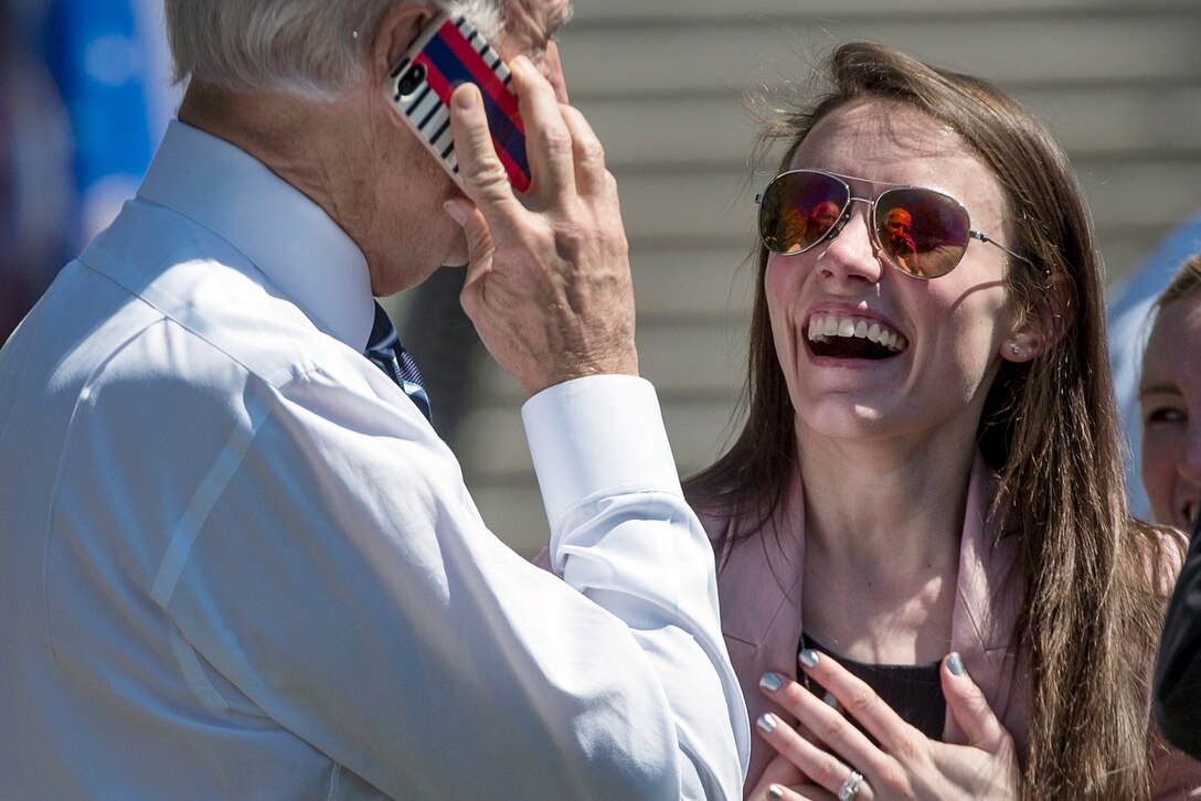 Elizabeth Welke of Iowa reacts to Vice President Joe Biden calling her husband on her phone at the White House in Washington, D.C., April 16, 2015. Welke was supporting the annual Wounded Warrior Project's soldier ride at the White House when Biden made the call. 
