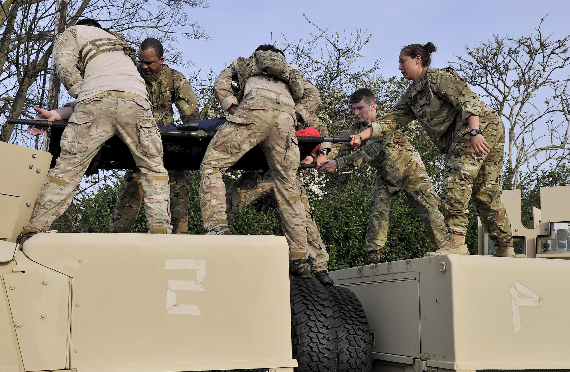 A team carries Mr. Hurt, a dummy, over two HUMVEEs April 10, 2015, during the Monster Mash on RAF Mildenhall, England. The Monster Mash consisted of various events such as navigating across a “lava” pit, pulling a Humvee and a blind weapons assembly. (U.S. Air Force photo by Airman 1st Class Kyla Gifford)