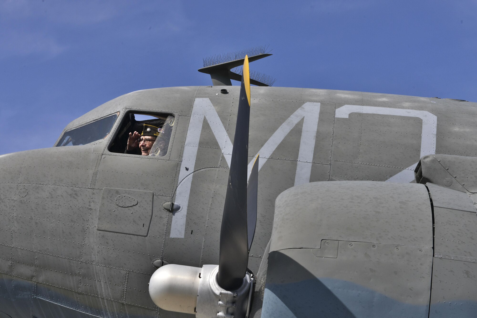 Retired Lt. Col. Alston Daniels salutes out of the window of a Douglas C-47D Skytrain on static display at Fairchild Air Force Base, Wash., April 7, 2015. Daniels flew the C-47 during World War II and logged nearly 2,000 hours in the aircraft. (U.S. Air Force photo/Staff Sgt. Alex Montes)