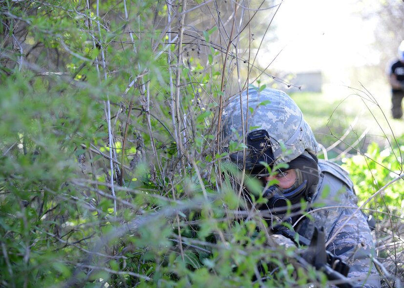 Senior Airman Corey Kennedy, 47th Security Forces Squadron defender, uses shrubbery for concealment at Laughlin Air Force Base, Texas. During a Security Forces live-fire exercise, defenders were taught the difference between cover and concealment. (U.S. Air Force photo by Airman 1st Class Jimmie D. Pike)