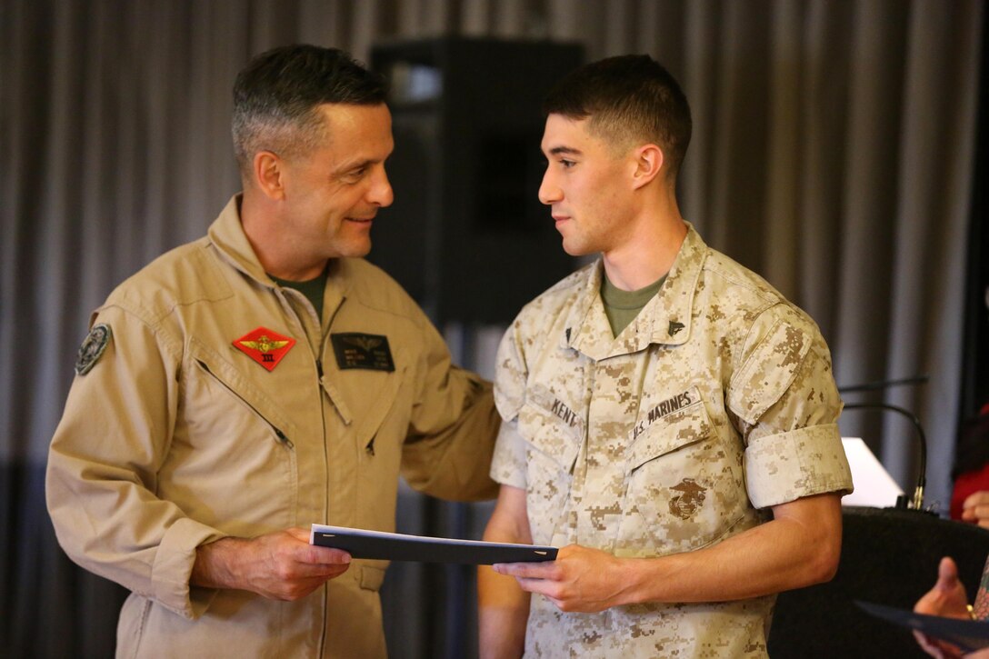 Maj. Gen. Michael Rocco, commanding general of 3rd Marine Aircraft Wing, left, presents an award to Cpl. Ryan Kent during the Volunteer Appreciation Celebration aboard Marine Corps Air Station Miramar, California, April 16. Kent received distinct recognition with the silver level of the President’s Volunteer Service award for more than 225 hours of volunteer service to the San Diego House Rabbit Society over the past year. (U. S. Marine Corps photo by Sgt. Melissa Wenger/Released)