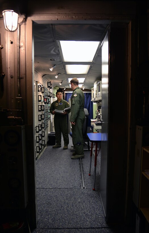 First Lt. Tony Onitsuka, left, the 10th Missile Squadron flight commander, and 1st Lt. Will Coley, the 10th MS deputy flight commander, check the status of their communications equipment March 16, 2015, at a launch control center near Malmstrom Air Force Base, Mont. Regular maintenance and checks are required to ensure there is a stable communications network to the LCC. (U.S. Air Force photo/Airman 1st Class Dillon Johnston)