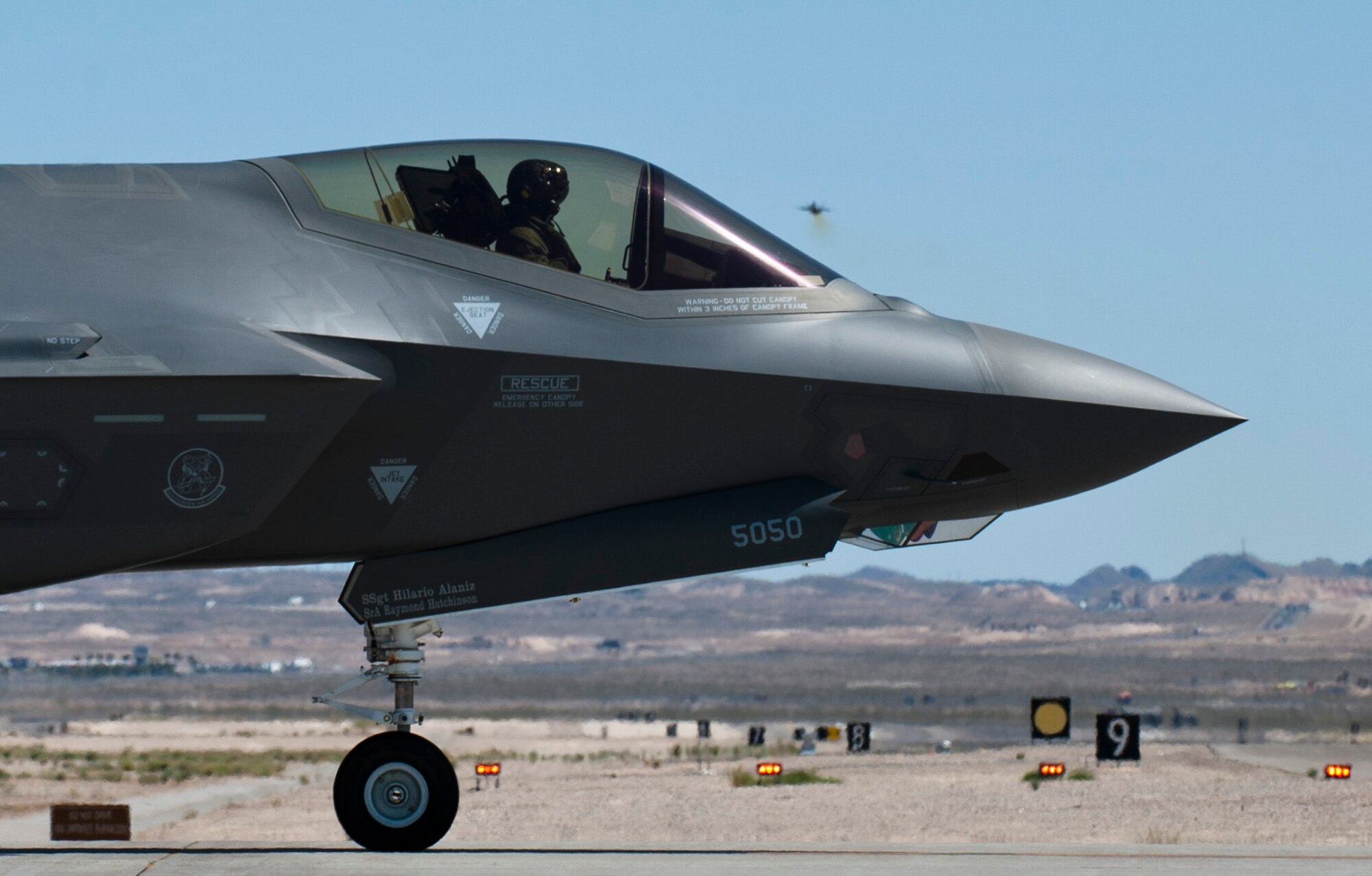 A Luke Air Force Base, Arizona F-35 Lightning II stands by to take off as another 61st Fighter Squadron F-35 soars into the Las Vegas skies April 15, 2015 at Nellis Air Force Base, Nevada. (U.S. Air Force photo by Senior Airman Thomas Spangler)