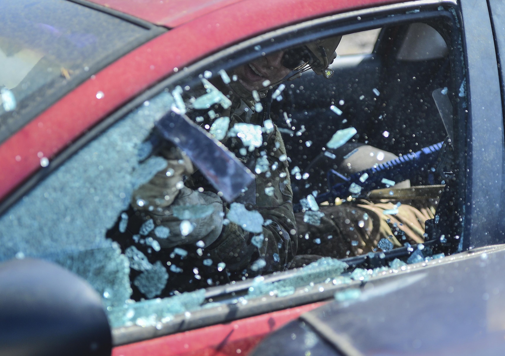 A Pararescueman from the Special Tactics Training Squadron breaks a window during extrication training at Hurlburt Field, Fla., April 8, 2014. The Special Tactics pararescuemen were training to retrieve injured or trapped personnel from vehicles and aircraft. (U.S. Air Force photo/Airman 1st Class Jeff Parkinson)
