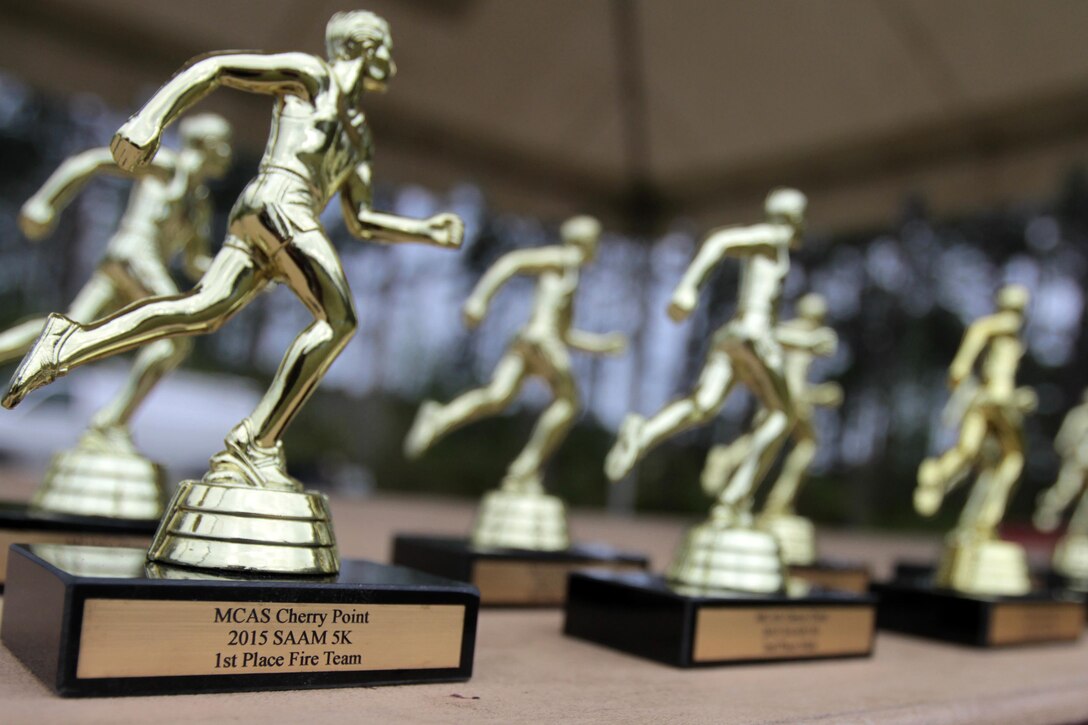 The individual and team trophies for participants in the Marine Corps Air Station Cherry Point and 2nd Marine Aircraft Wing Sexual Assault Awareness Month Commemorative 5K sit on display before the beginning of the race, April 17, 2015. 
The event drew nearly 1,000 Marines, Sailors and Department of Defense employees who ran the 3.1 mile course along Rifle Range Road to show solidarity with sexual assault survivors and a shared commitment to eradicating sexual violence across the Marine Corps.  