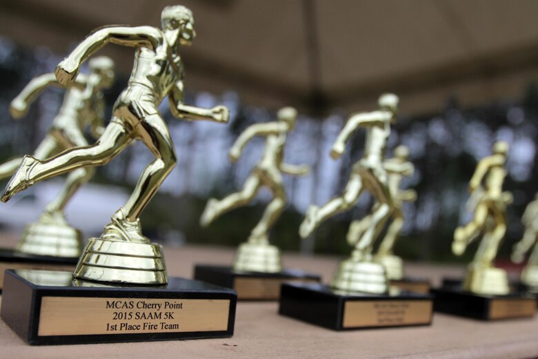 The individual and team trophies for participants in the Marine Corps Air Station Cherry Point and 2nd Marine Aircraft Wing Sexual Assault Awareness Month Commemorative 5K sit on display before the beginning of the race, April 17, 2015. 
The event drew nearly 1,000 Marines, Sailors and Department of Defense employees who ran the 3.1 mile course along Rifle Range Road to show solidarity with sexual assault survivors and a shared commitment to eradicating sexual violence across the Marine Corps.  