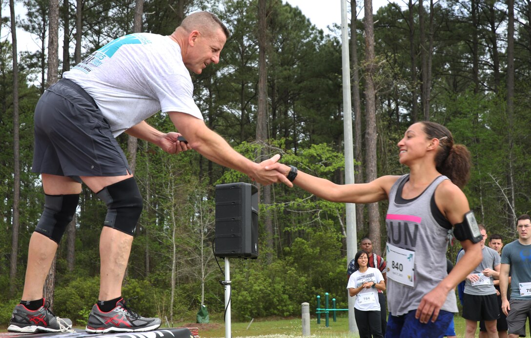 Maj. Gen. Robert Hedelund, commanding general of 2nd Marine Aircraft Wing, shakes hands with a participant in the Marine Corps Air Station Cherry Point and 2nd MAW Sexual Assault Awareness Month Commemorative 5K, April 17, 2015.
The event drew nearly 1,000 Marines, Sailors and Department of Defense employees who ran the 3.1 mile course along Rifle Range Road to show solidarity with sexual assault survivors and a shared commitment to eradicating sexual violence across the Marine Corps.  