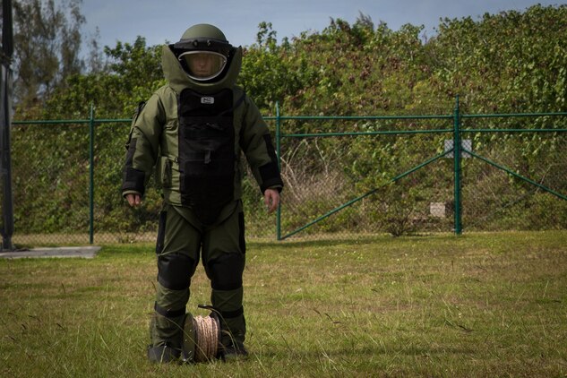 Staff Sgt. Steven M. Smith, a team leader with Explosive Ordnance Disposal Headquarters Battalion, wears a bomb suit and prepares to conduct mechanical entry of a car utilizing hook and line during a International Association of Bomb Technicians & Investigators conference aboard Marine Corps Base Hawaii, March 15, 2015. (U.S. Marine Corps photo by Cpl. Brittney Vella/Released)