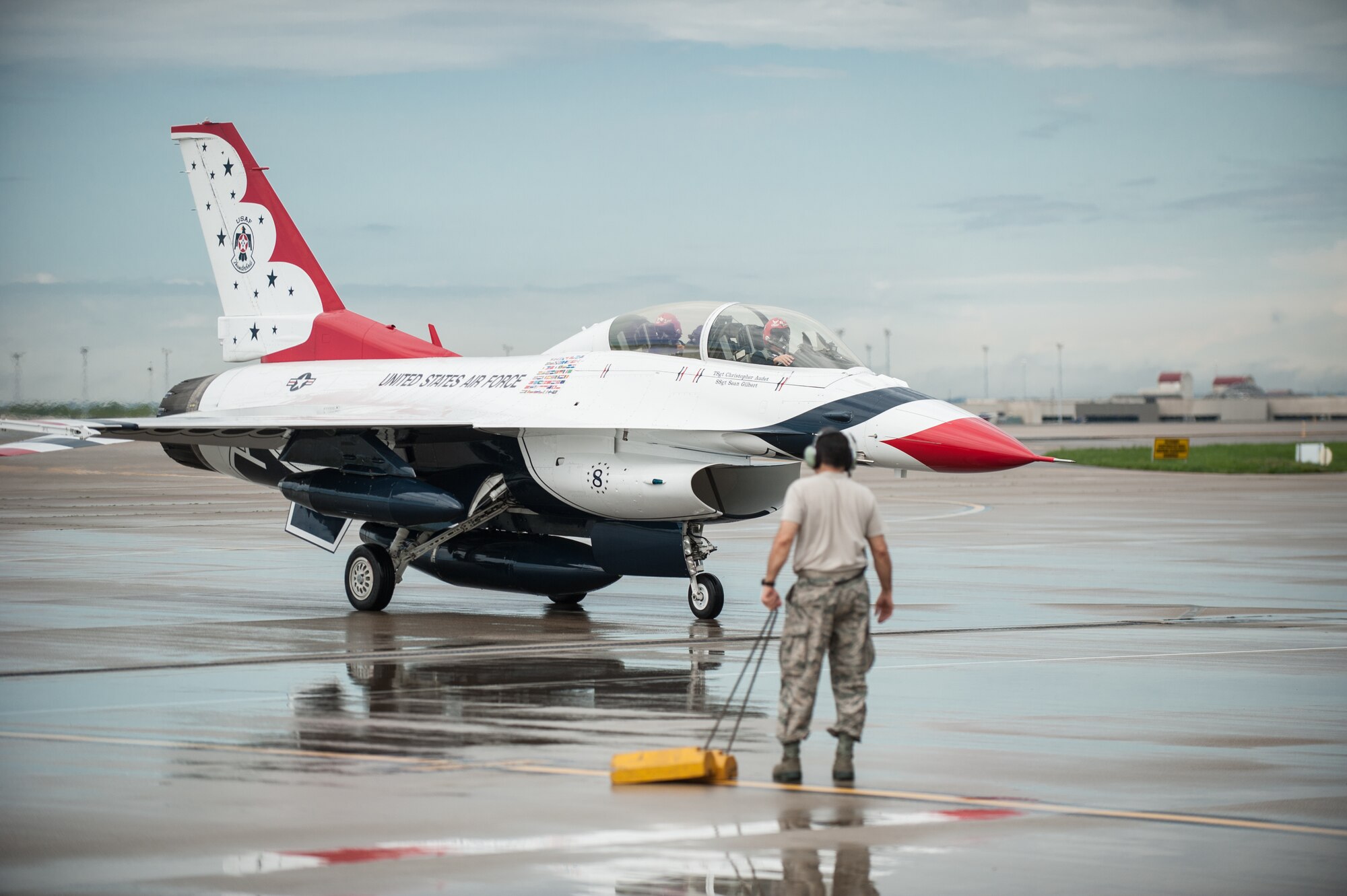 An Airman from the 123rd Airlift Wing prepares to chock the wheels of a U.S. Air Force Thunderbirds F-16 aircraft at the Kentucky Air National Guard Base in Louisville, Ky., April 16, 2015. The Thunderbirds are performing in the 2015 Thunder Over Louisville air show, to be held April 18 over the Ohio River in downtown Louisville. The Kentucky Air Guard is providing logistical support to military aircraft flying in the air show. (U.S. Air National Guard photo by Maj. Dale Greer)