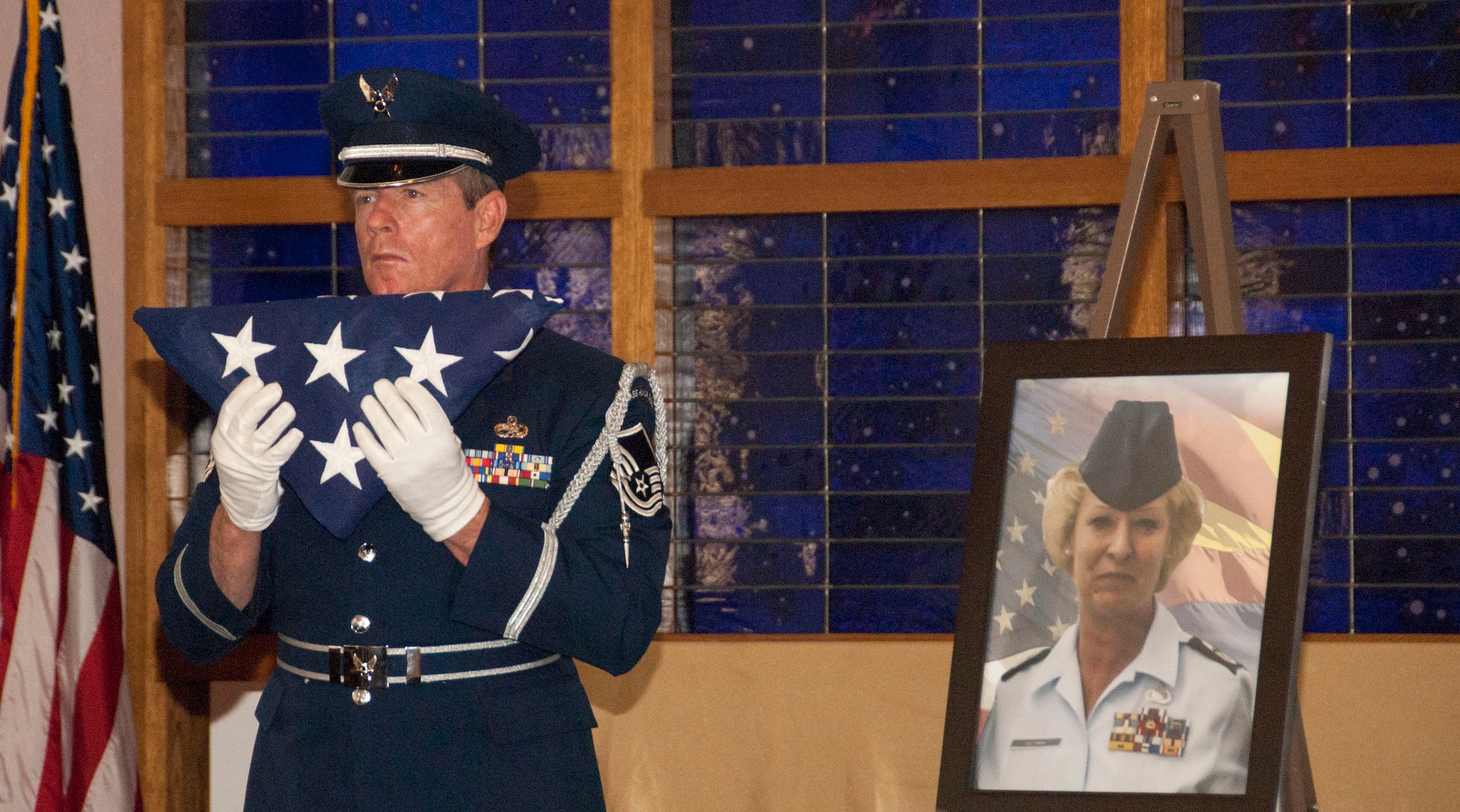 Master Sgt. Norman Enfinger, an honor guardsman at the 162nd Wing, holds a folded flag to honor retired Command Chief Master Sgt. Karen Veltman during her memorial ceremony April 11, 2015. Veltman was the first woman to join the 162nd Wing, and the first female command chief master sergeant at the wing. She dedicated 32 years of her life to the 162nd, its members and their families. Veltman passed away in March. (U.S. Air National Guard Photo/Staff Sgt. Gregory Ferreira)