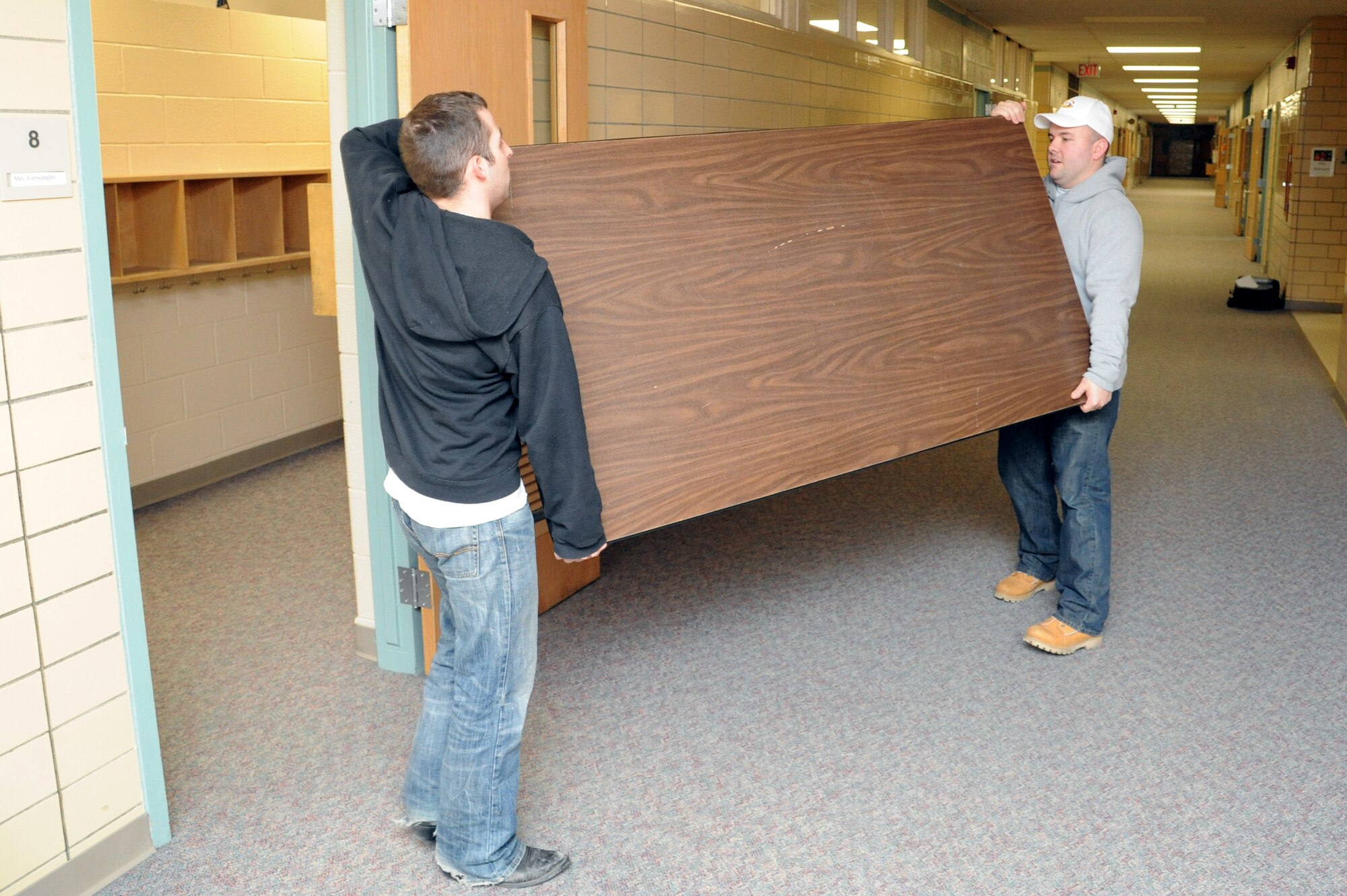 Airmen from Grand Forks Air Force Base move furniture at Carl Ben Eielson Elementary School April 8, 2015, on Grand Forks Air Force Base, N.D. The incoming Air Mobility Command Inspector General capstone team will utilize a series of classrooms at the school for group interviews with members of the base. (U.S. Air Force photo by Staff Sgt. David Dobrydney/Released)
