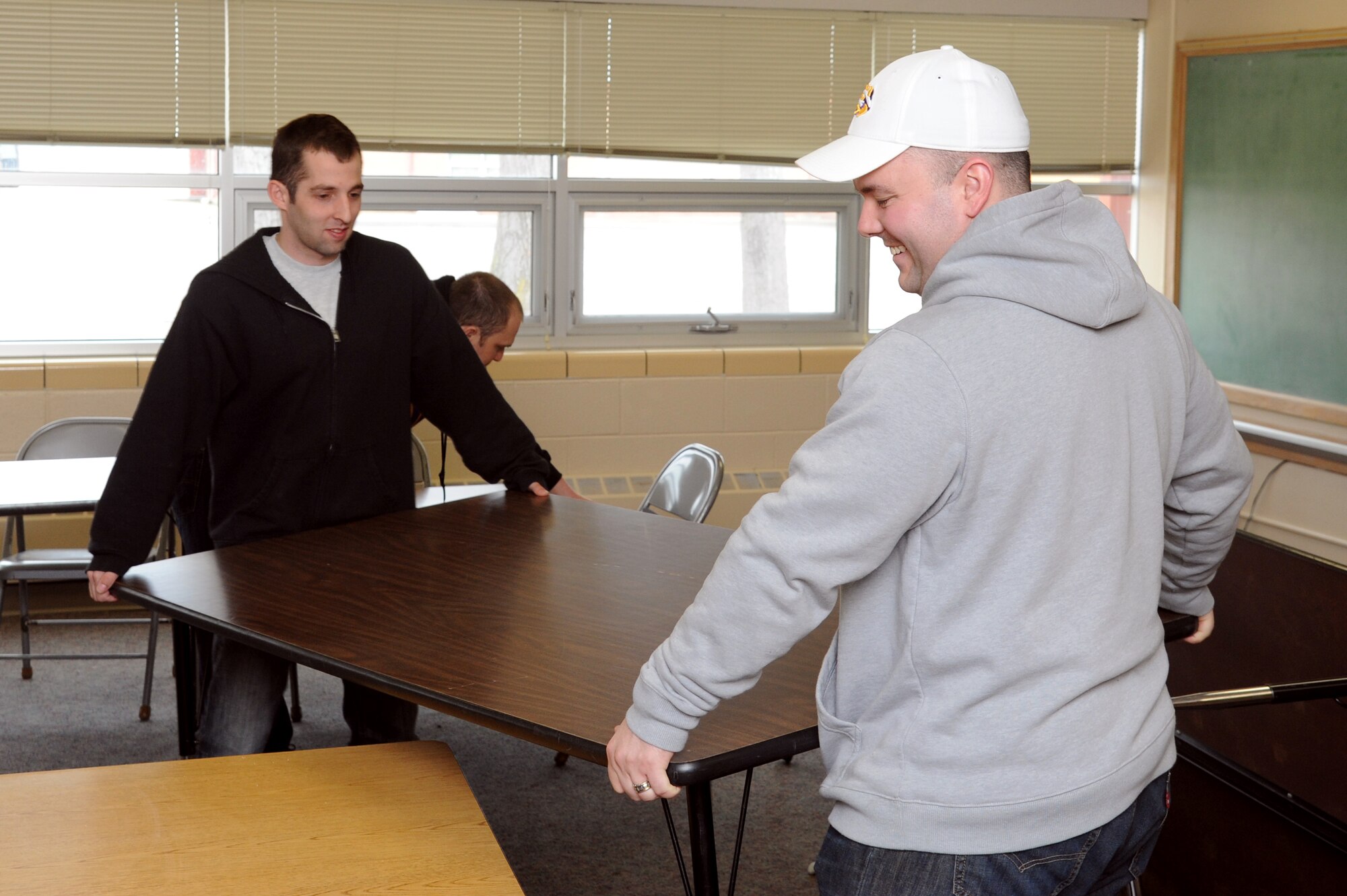 Airmen from Grand Forks Air Force Base arrange furniture in a Carl Ben Eielson Elementary School classroom April 8, 2015, on Grand Forks Air Force Base, N.D. The incoming Air Mobility Command Inspector General capstone team will utilize a series of classrooms at the school for group interviews with members of the base. (U.S. Air Force photo by Staff Sgt. David Dobrydney/Released)