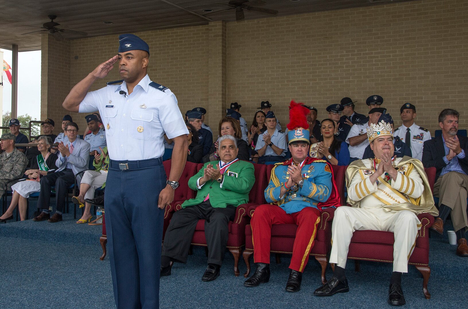 Col. Trent Edwards, 37th Training Wing commander, renders a salute during the Basic Military Training graduation parade, while, from rear left, 2015 Fiesta Royalty, Fernando Reyes, Fiesta San Antonio Commission president, Mark M. Johnson Jr., Texas Cavaliers King Antonio the 93rd, and Jon Gary Herrera, El Rey Feo the 67th, observe April 17, 2015, at Joint Base San Antonio-Lackland, Texas. The full-scale Basic Military Training Graduation Parade is the only military graduation incorporated into Fiesta and features more than 1,000 distinctive military members and the 323rd Training Squadron Drum and Bugle Corps. Fiesta San Antonio, the city's 11-day cascarón-filled celebration, began as a one-time parade in 1891 to honor the memory of the heroes of the Alamo and the Battle of San Jacinto. Over the past century, Fiesta has grown into a celebration of San Antonio's rich and diverse cultures. Military representative from throughout San Antonio participate in receptions, parades, pilgrimages and memorials. (U.S. Air Force photo by Johnny Saldivar/released)