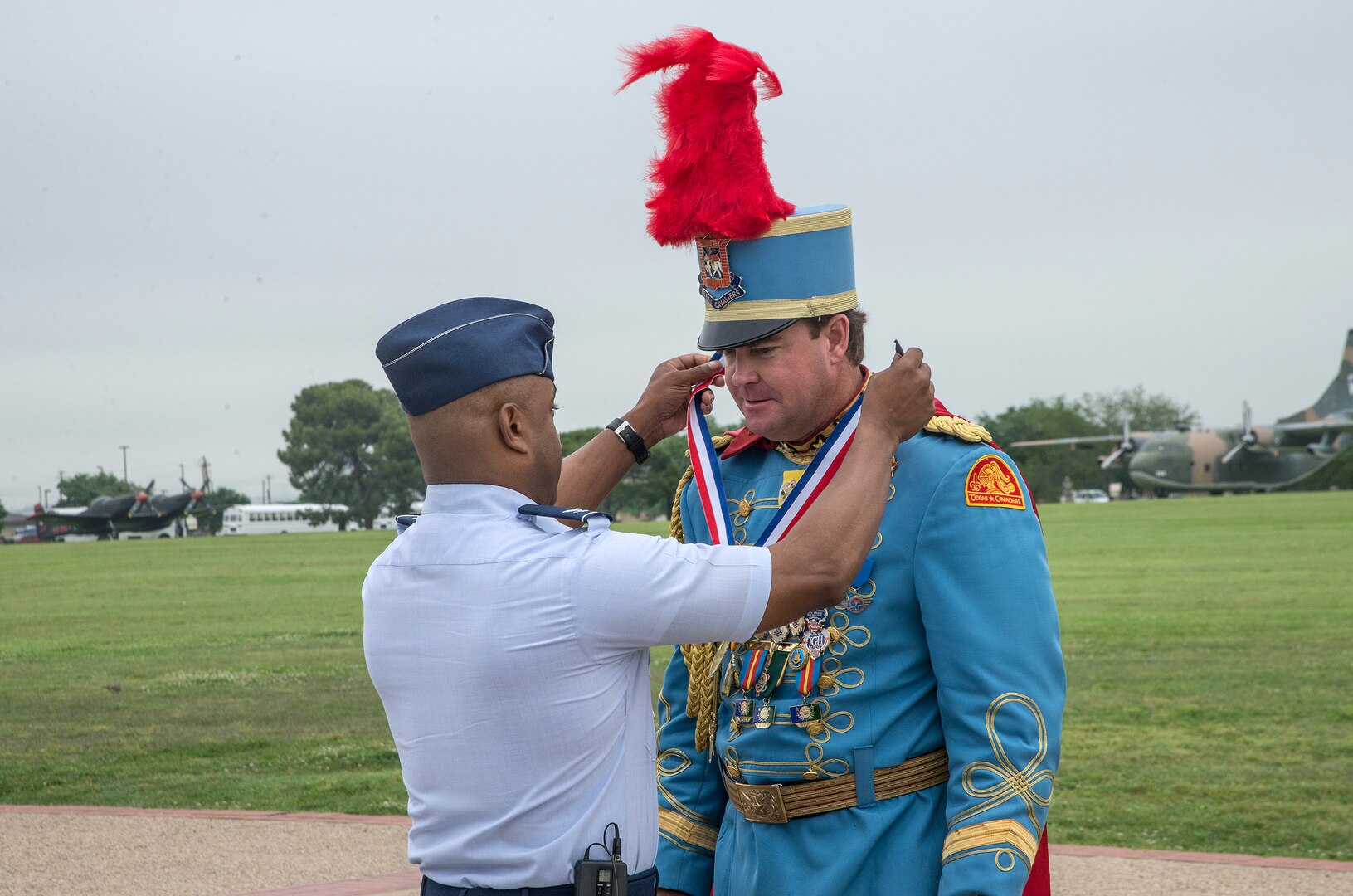 Col. Trent Edwards, 37th Training Wing commander, presents a Fiesta Medal to 2015 Fiesta Royalty, Mark M. Johnson Jr., Texas Cavaliers King Antonio the 93rd, April 17, 2015, at Joint Base San Antonio-Lackland, Texas. The full-scale Basic Military Training Graduation Parade is the only military graduation incorporated into Fiesta and features more than 1,000 distinctive military members and the 323rd Training Squadron Drum and Bugle Corps. Fiesta San Antonio, the city's 11-day cascarón-filled celebration, began as a one-time parade in 1891 to honor the memory of the heroes of the Alamo and the Battle of San Jacinto. Over the past century, Fiesta has grown into a celebration of San Antonio's rich and diverse cultures. Military representative from throughout San Antonio participate in receptions, parades, pilgrimages and memorials. (U.S. Air Force photo by Johnny Saldivar/released)

