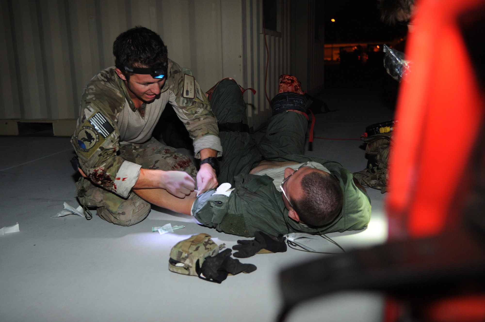 A U.S. Air Force Senior Airman from the 48th Rescue Squadron prepares to initiate an IV fluid resuscitation on a simulated patient during a mass casualty exercise at Davis-Monthan Air Force Base, Ariz., April 14, 2015.  For this exercise, several Airmen volunteered to play victims. This element added realism to the training, allowing the pararescuemen to work through the stress that each mission can bring. Due to security concerns, the last name is withheld. (U.S. Air Force photo by Senior Airman Betty R. Chevalier)