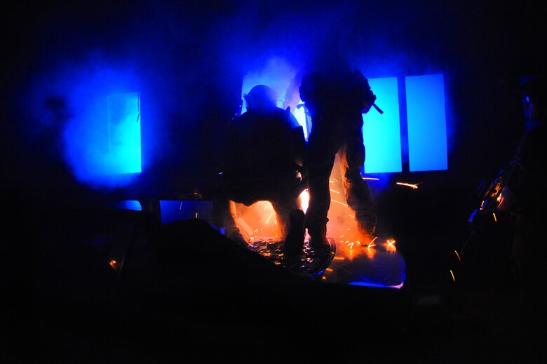 U.S. Air Force Pararescuemen assigned to the 48th Rescue Squadron use a grinder to gain access to a helicopter during a simulated crash at Davis-Monthan Air Force Base, Ariz., April 14, 2015. The crash was part of pre-deployment training that focused on mass casualty treatment, evacuation, extrication and confined space/collapsed structure rescue.  (U.S. Air Force photo by Senior Airman Betty R. Chevalier)