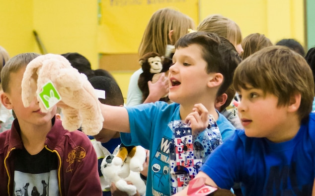 Children from Stephensen Elementary School play with their stuffed “Ruffy” toys after a reading from their Principal, Phil McCluskey at Mountain Home Air Force Base, April 2, 2015. The local community donated the toys as part of an education initiative to inspire Mountain Home children with a passion for reading. (U.S. Air Force photo by 2nd Lt. Kip Sumner/RELEASED)