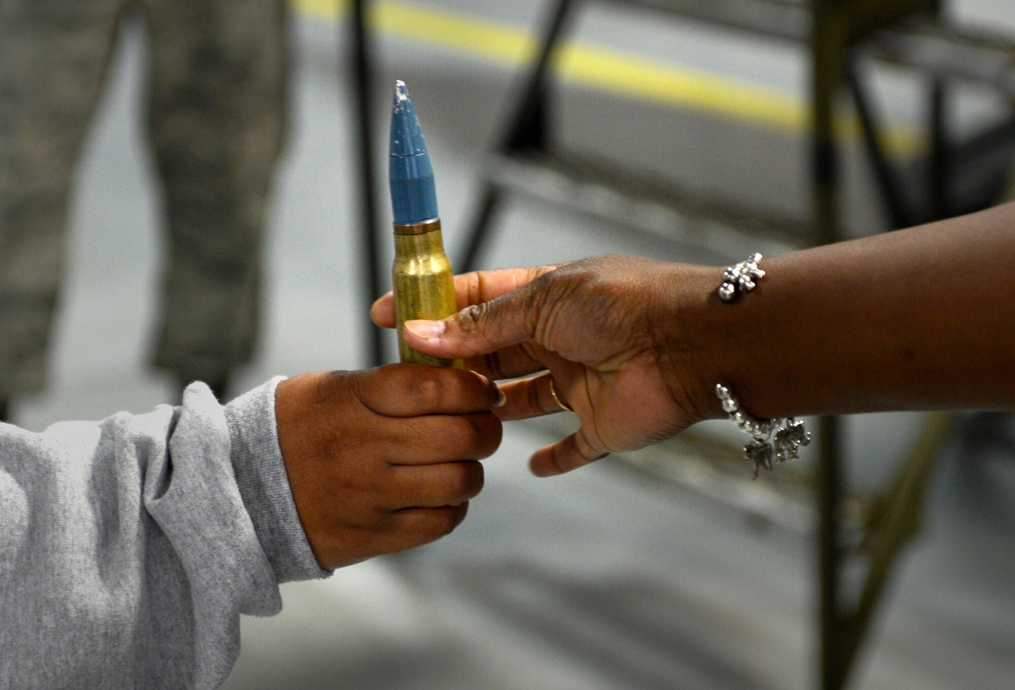 A 20mm round is passed by participants of the newcomers tour at Shaw Air Force Base, S.C., April 16, 2015. The tour is provided to give new Team Shaw members and their families an in-depth look at the mission of the 20th Fighter Wing. (U.S. Air Force photo by Senior Airman Jensen Stidham/Released)