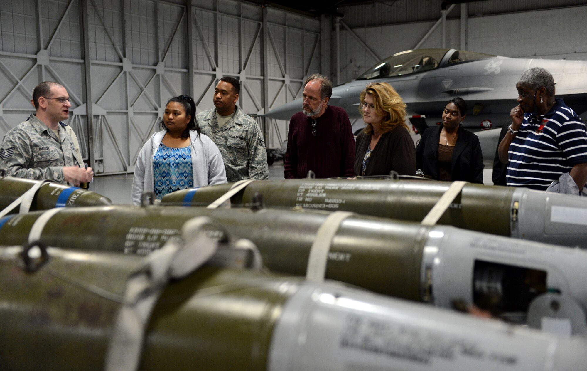 U.S. Air Force Tech. Sgt. Thad Burton, 20th Maintenance Group weapons and standardization load crew member, speaks to a Newcomers Tour group at the weapons and standardization building at Shaw Air Force Base, S.C., April 16, 2015. During the first tour of its kind, participants received an inside look at the mission of the 20th Fighter Wing. (U.S. Air Force photo by Senior Airman Jensen Stidham/Released)