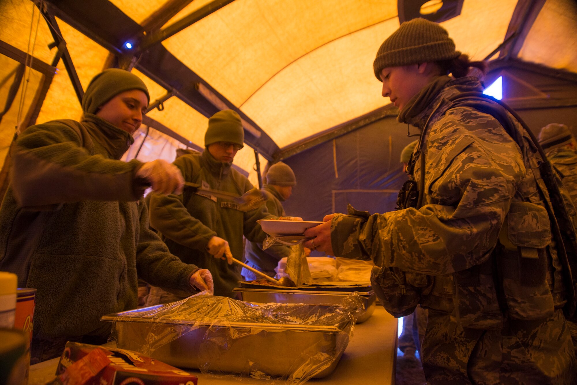 Airmen stand in line to receive a warm meal during Gunfighter Flag 15-2 at Saylor Creek Range, Idaho, April 15, 2015. Dining facility airmen used a tray ration heater to prepare food for exercise participants looking for a warm meal on an unseasonably cold day. (U.S. Air Force photo by Staff Sgt. Roy Lynch III/Released)