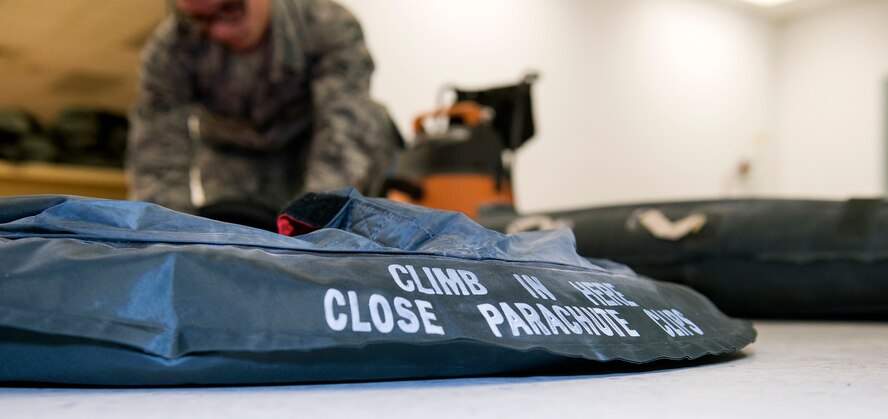 U.S. Air Force Airman 1st Class Tyler Johnson, 347th Operations Support Squadron aircrew flight equipment technician, deflates an LRU-16/P one-man life raft in preparation for a six hour leakage test April 15, 2015, at Moody Air Force Base, Ga. The raft is labeled with several basic procedure reminders to alleviate potential panic and stressful encounters for aircrew members during an emergency. (U.S. Air Force photo by Airman Greg Nash/Released)
