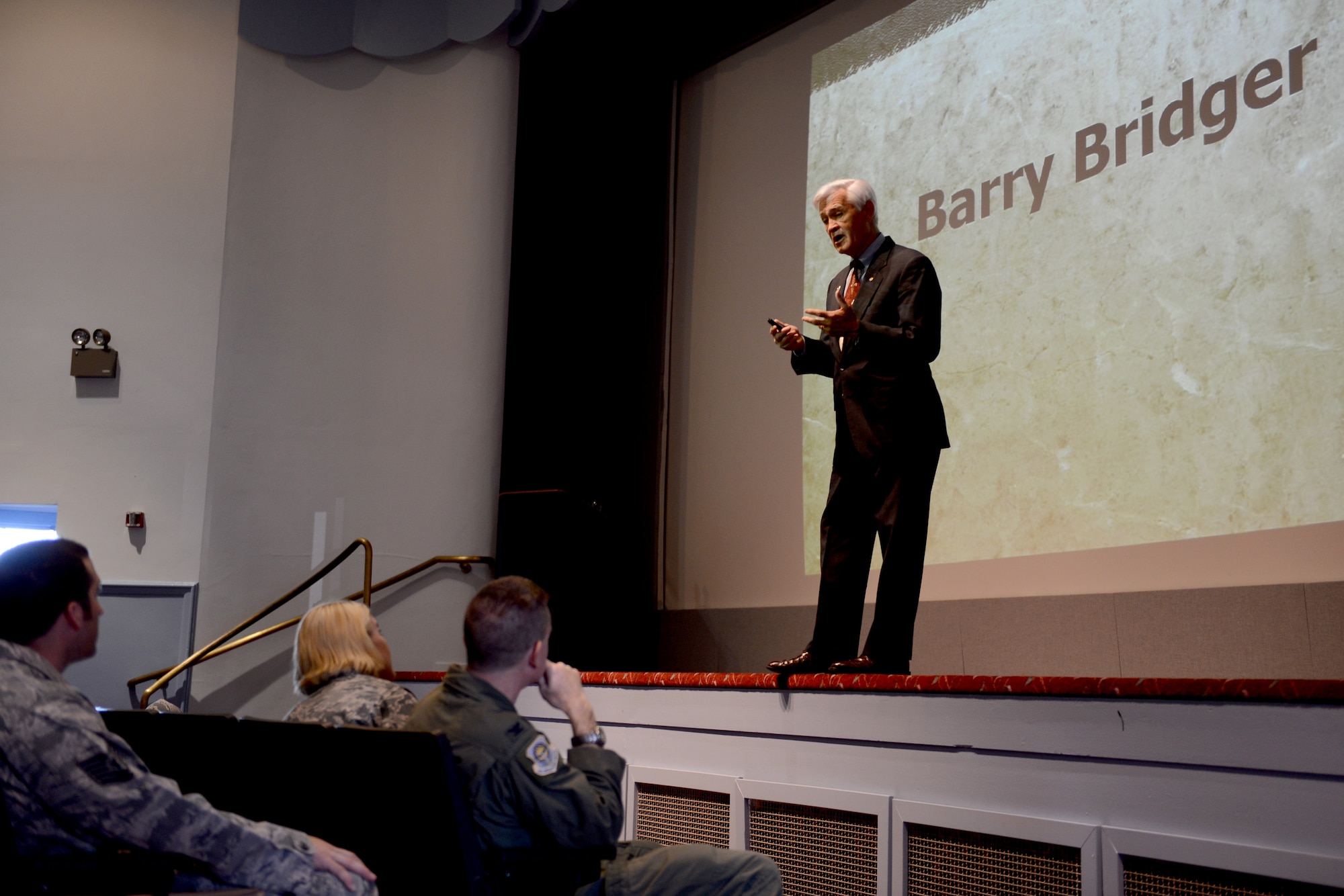 Retired Lt. Col. Barry Bridger, former prisoner of war, gives a speech, April 16, 2015, at Joint Base Lewis-McChord, Wash. Bridger gave a slideshow presentation of his experience and explained how he survived. (U.S. Air Force photo/Airman 1st Class Keoni Chavarria)