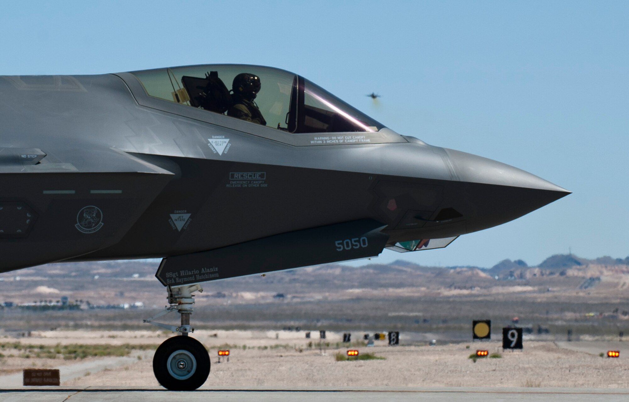 A Luke Air Force Base F-35 stands by to take off as another 61st Fighter Squadron Lightning II soars into the Las Vegas skies April 15, 2015 at Nellis Air Force Base, Nevada. (U.S. Air Force photo by Senior Airman Thomas Spangler)